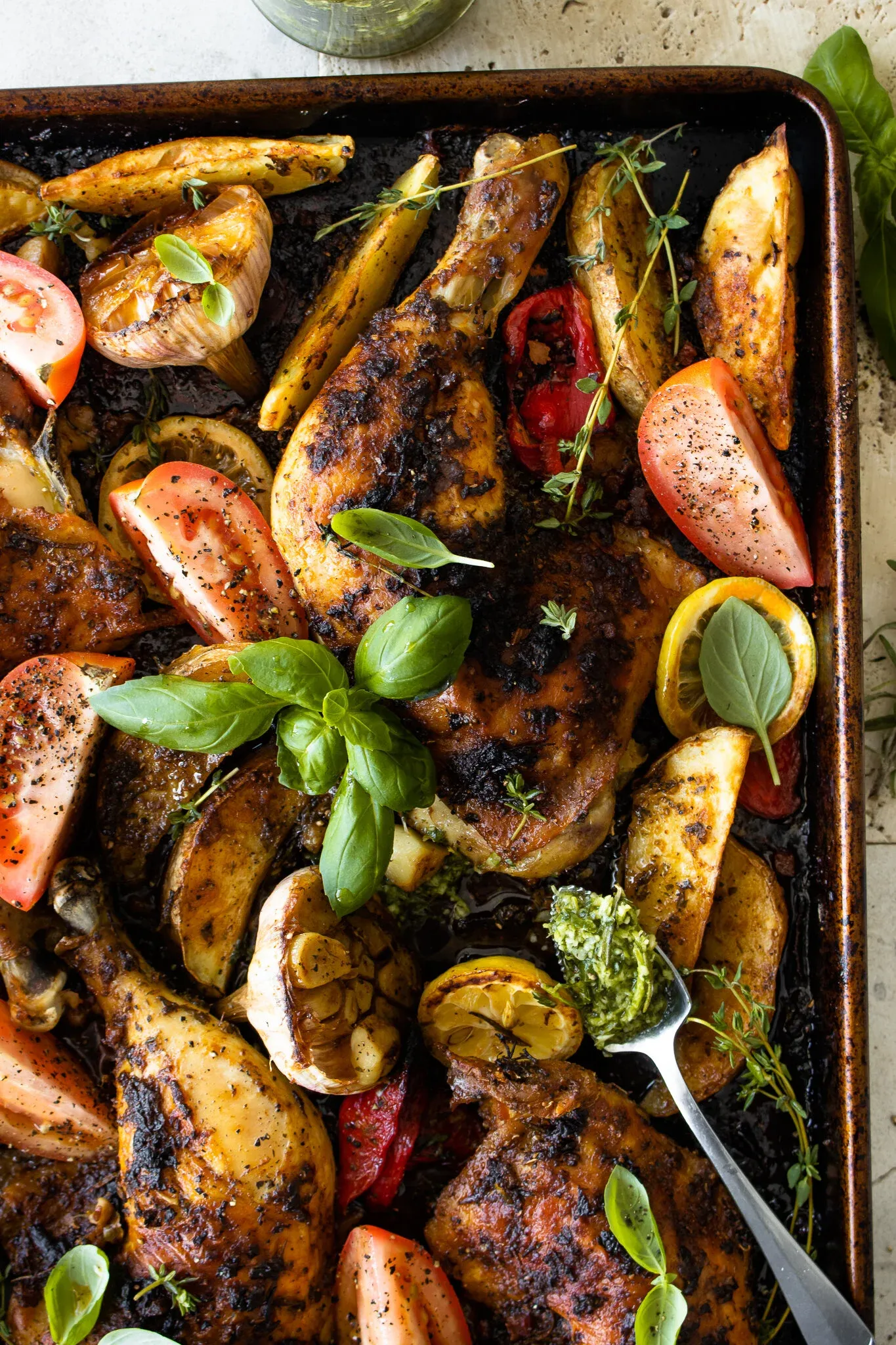 Angled overhead close-up of the sheet pan showing the crispy deeply charred spice-rubbed skin of the Dominican Roasted Chicken legs