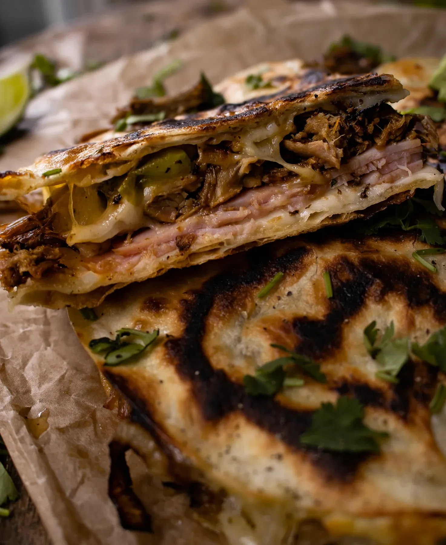 Close-up side-angle cross-section of a stacked Cubano Inspired Quesadilla slice revealing distinct layers of shredded roasted pork