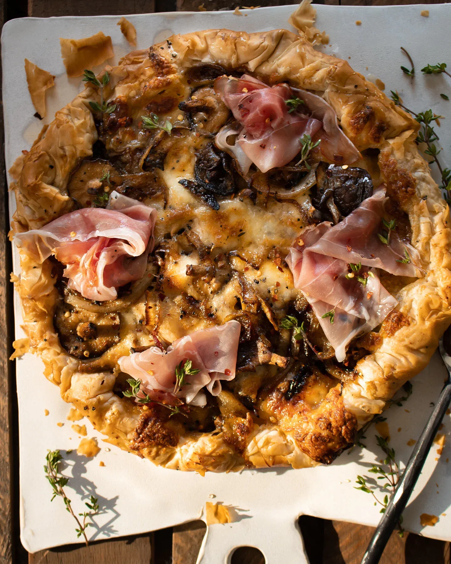 Close overhead view of the phyllo tart filling, highlighting the deeply caramelized onions