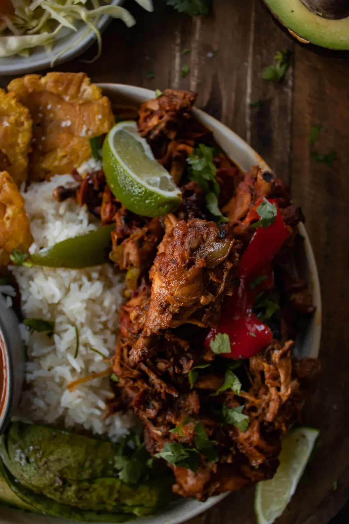 Close-up angled shot of the braised pollo guisado (Dominican stewed chicken) portion of La Bandera Dominicana