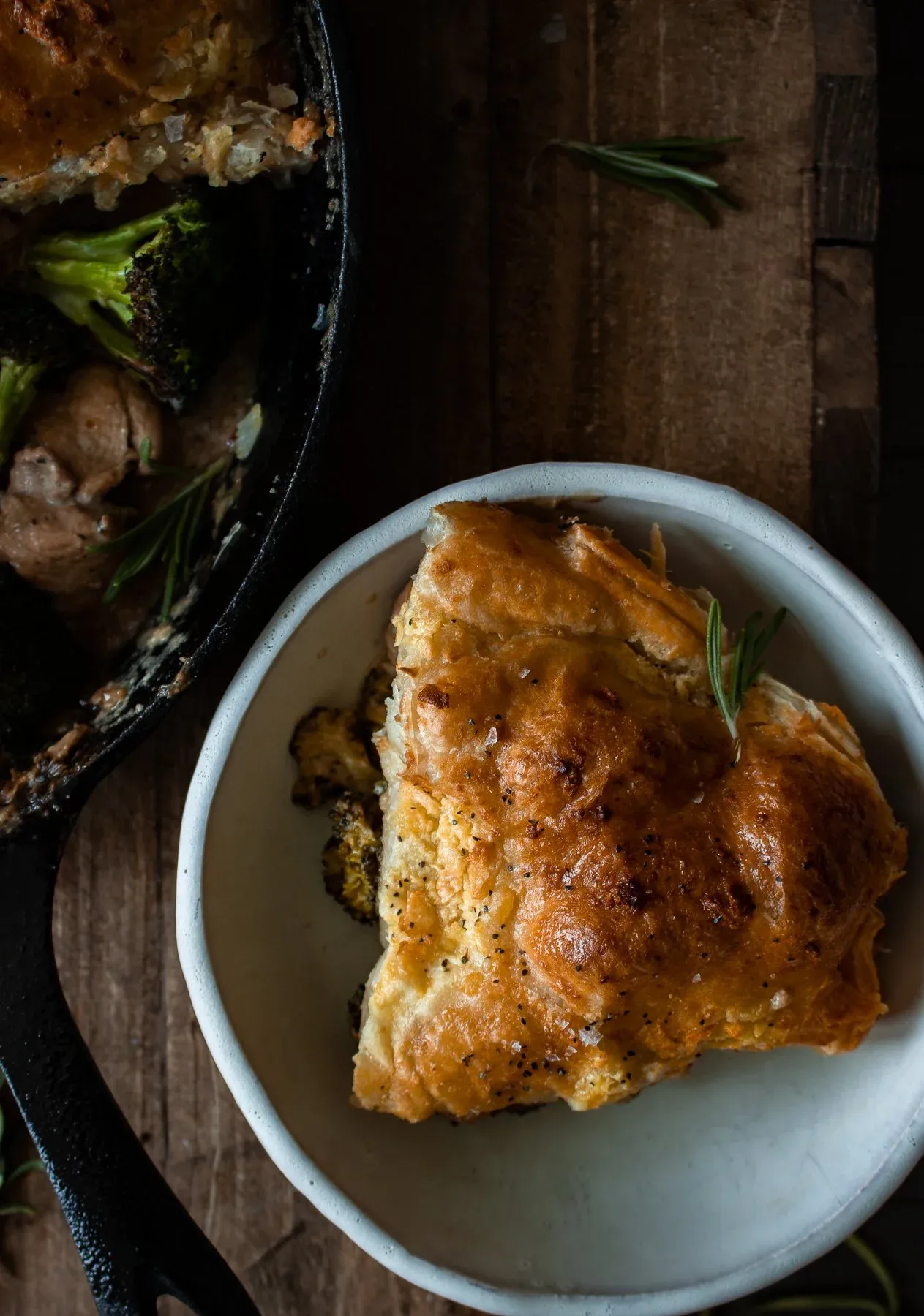 Overhead close-up of a single white bowl serving of Roasted Broccoli and Chicken Pot Pie