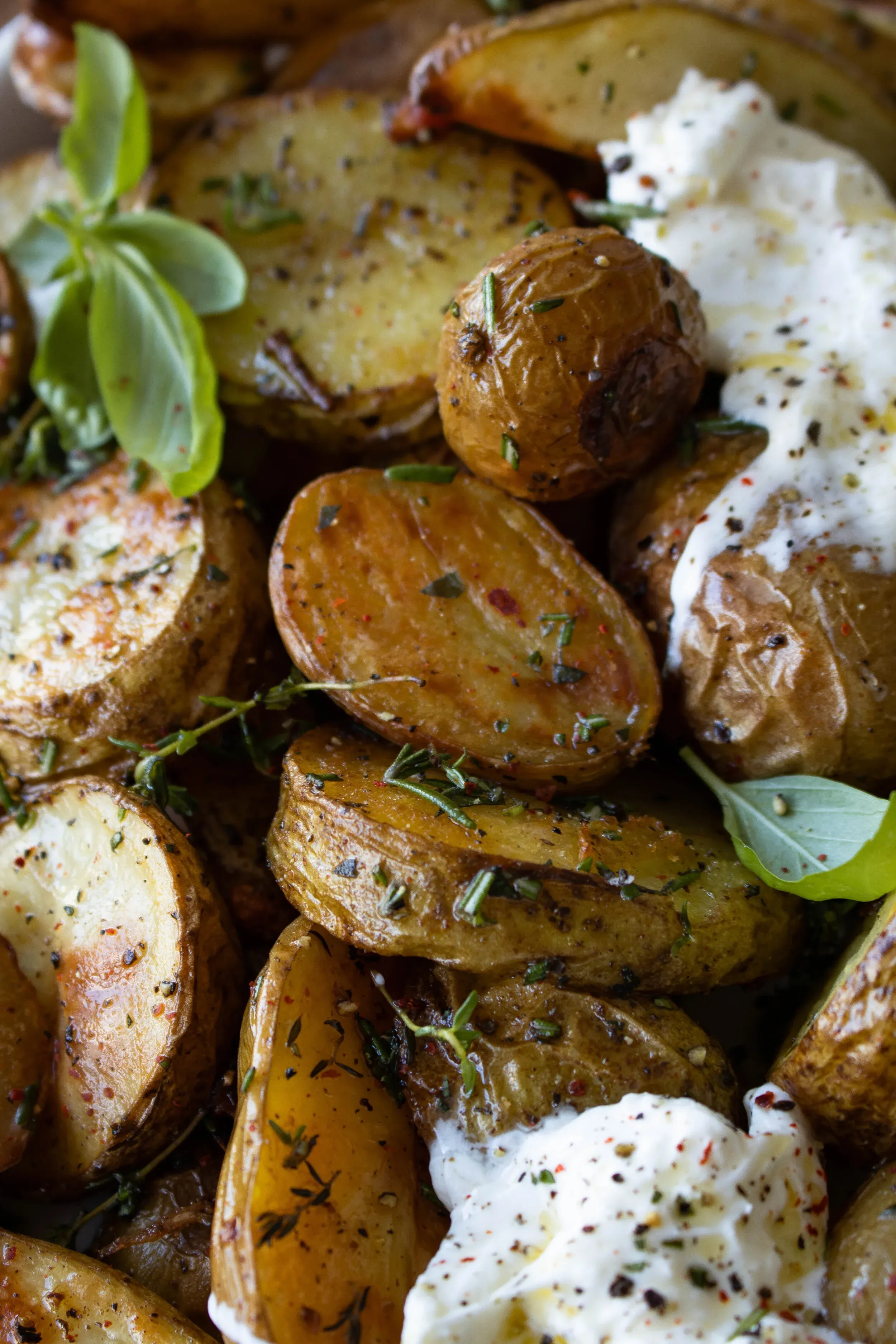 Golden roasted herby potatoes piled in a bowl