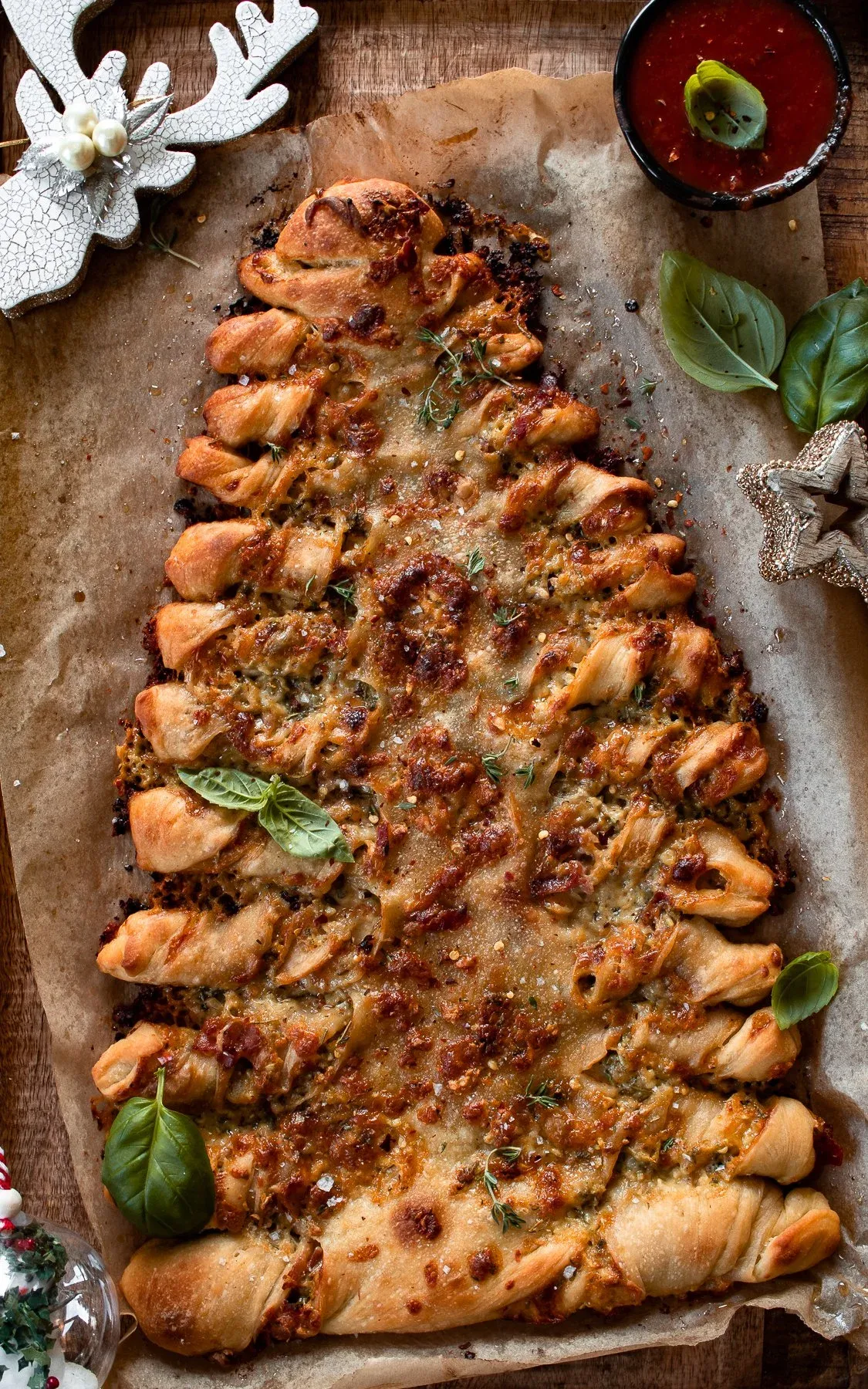 Freshly baked Christmas Tree Pull Apart Bread on parchment paper on a wooden board