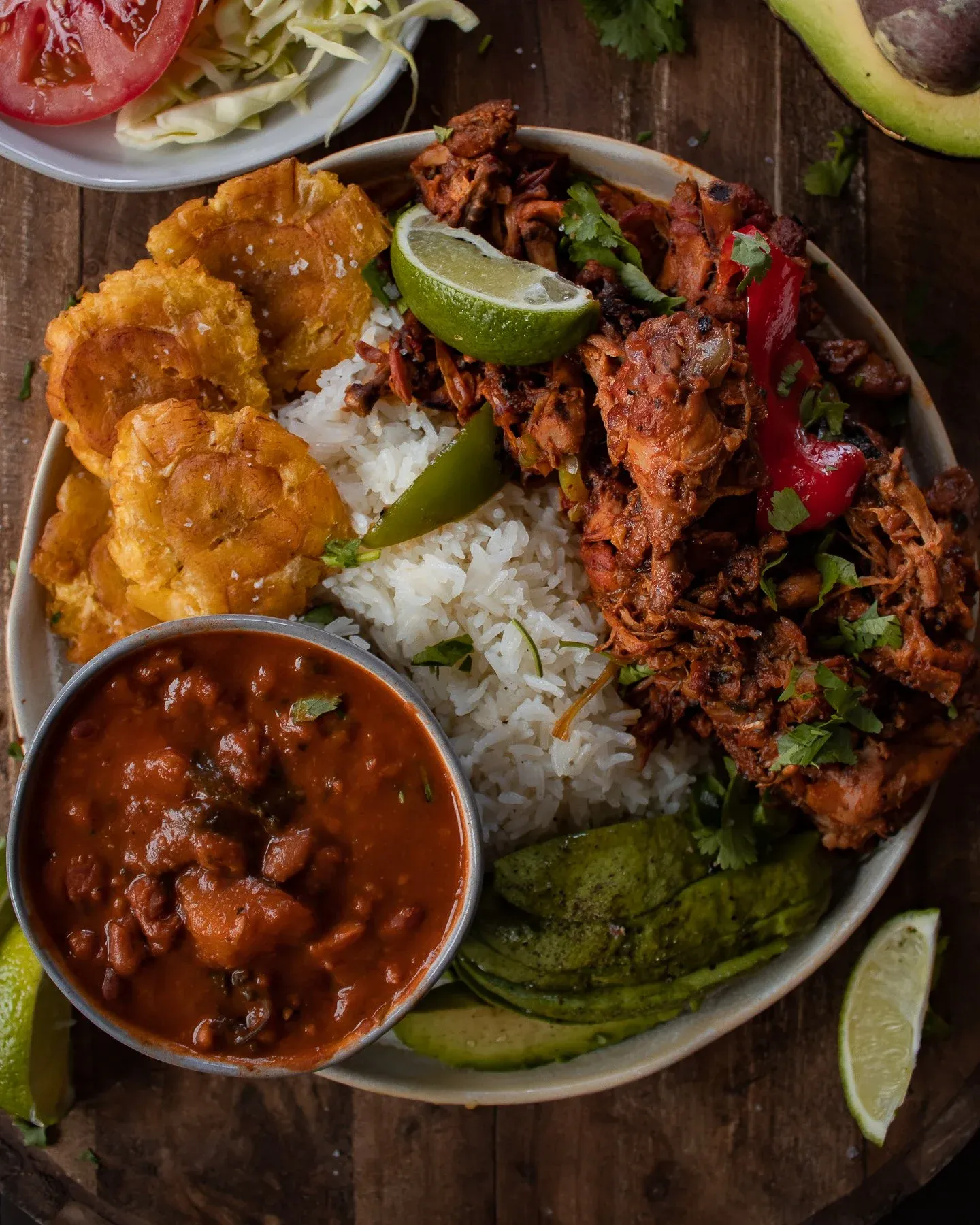 Wide angled overhead of the La Bandera Dominicana bowl showing all four components clearly — golden tostones