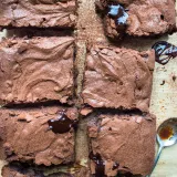 Six rectangular gluten free espresso brownies arranged on parchment paper viewed directly overhead