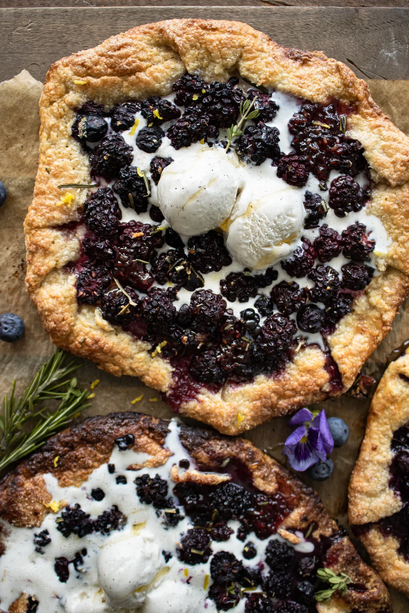 Overhead shot of a large Berry Galette with Honey Goat Cheese topped with two scoops of softly melting ice cream