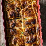 Apple and Bourbon Pandowdy just out of the oven in a red scalloped ceramic baking dish