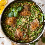 One Skillet Chicken and Orzo with Spring Veggies in a large stainless steel two-handled pan