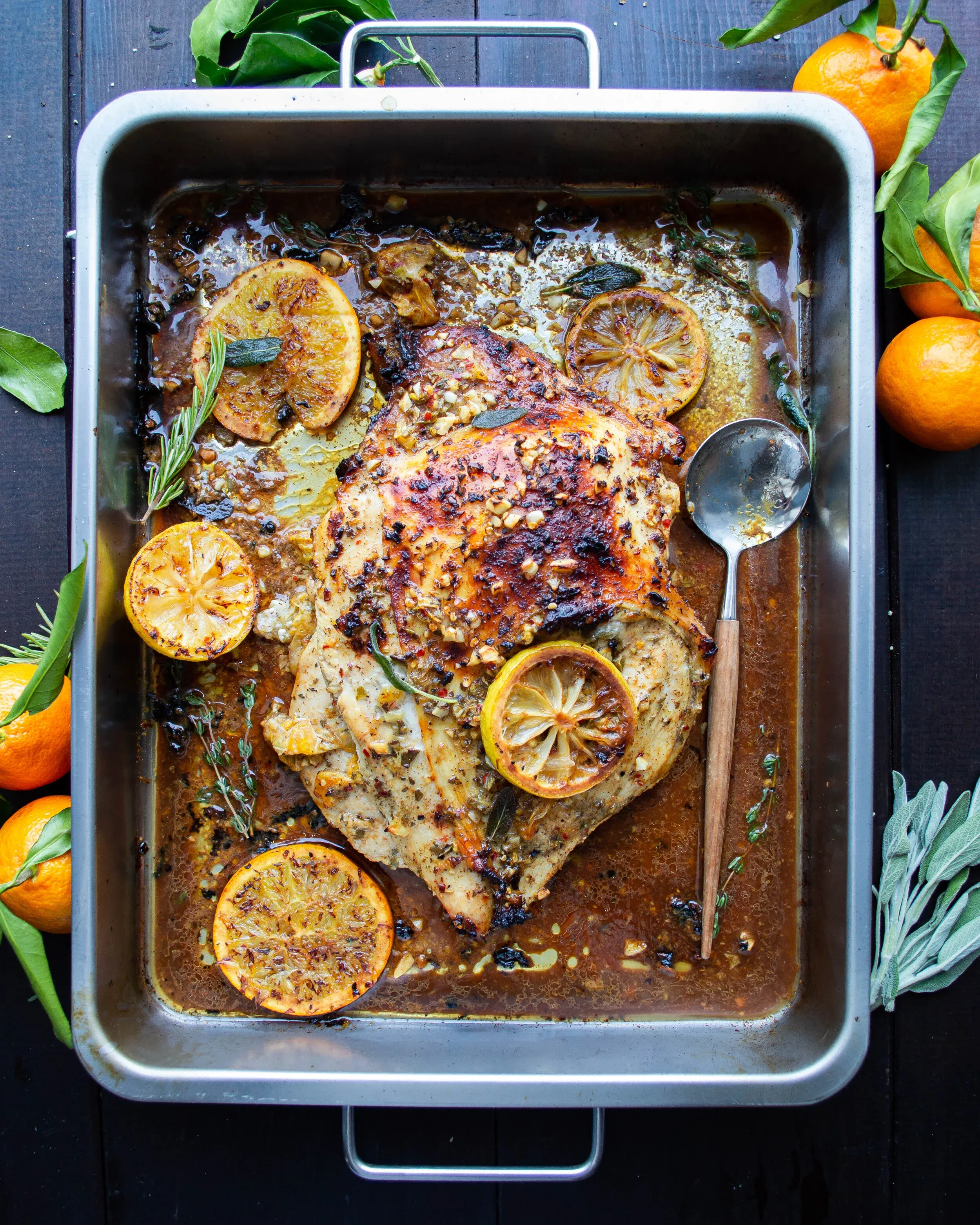Overhead view of Herby Wine and Citrus Marinated Turkey Breast freshly roasted in a stainless steel rectangular roasting pan